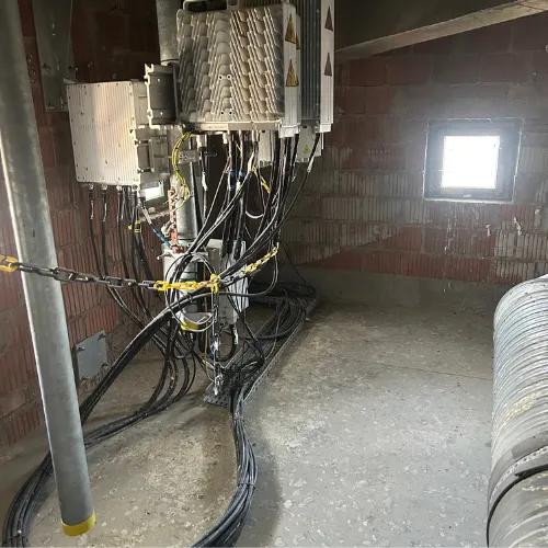 Photo d'une opération de dépigeonnage dans un local industriel avec tableau électrique. La photo montre des fientes de pigeons au sol.
