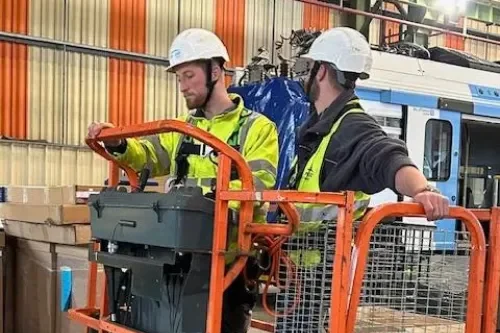 Photo de deux techniciens sur une nacelle pour la pose de dispositifs de dépigeonnage dans une industrie à Lille.